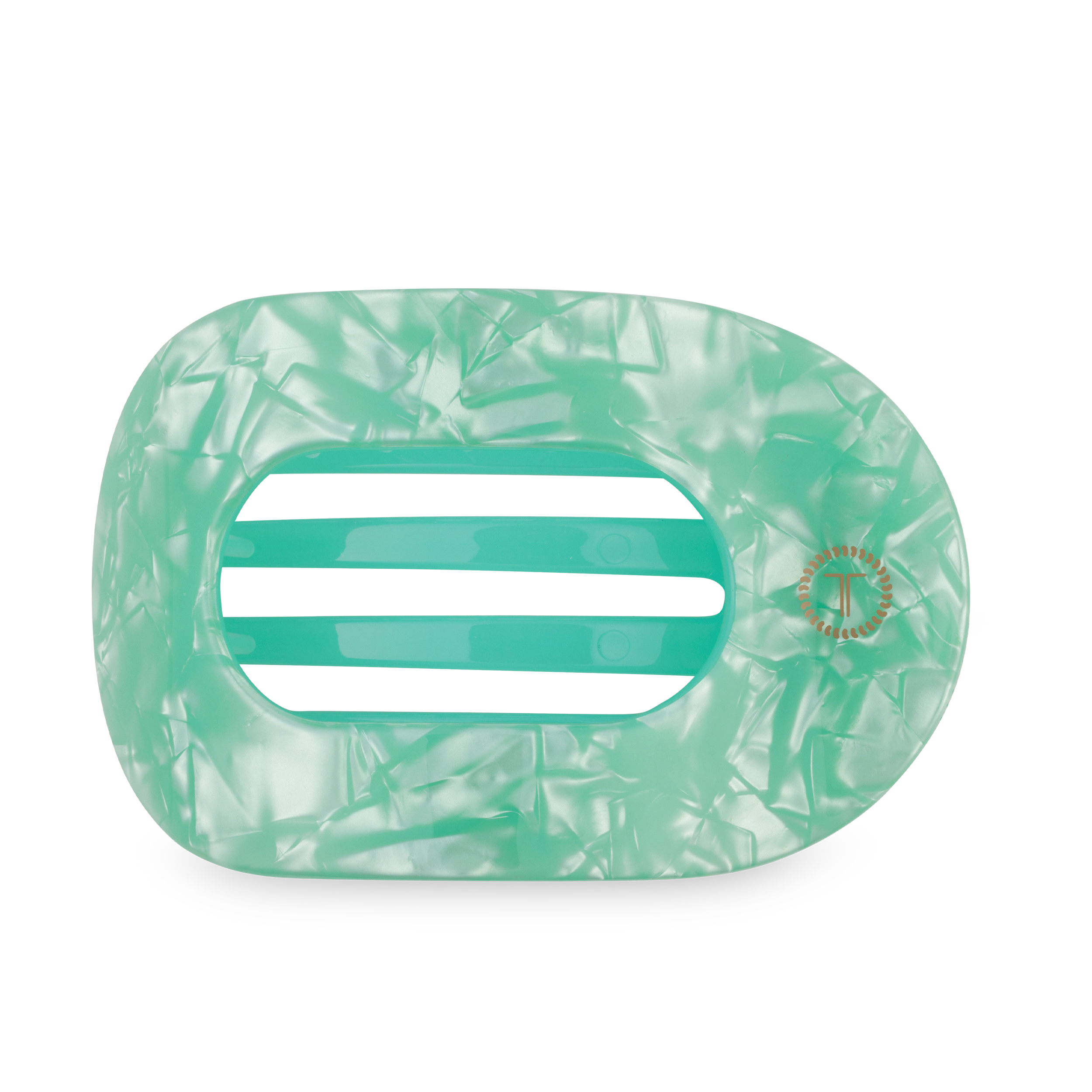 Large green flat round hair clip on a light surface