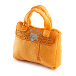 Bright orange plush handbag-shaped dog toy with a built-in squeaker.