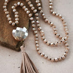 Debbie Pendant Necklace with Tassel in Champagne featuring leather tassel pendant and glass crystal bead necklace.