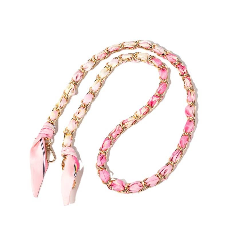 Light pink abstract patterned scarf woven through gold chain bag strap with clasps.