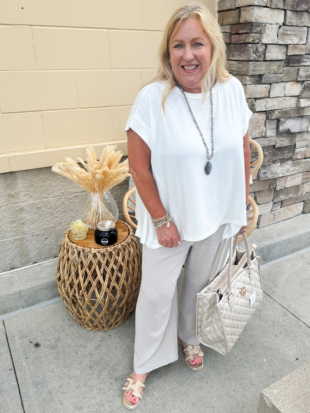 Wide-leg linen pants in a stone color with high-rise waist and pockets, styled for casual elegance.