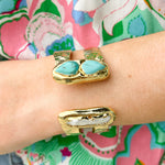 Gold double cuff bracelet featuring a mother of pearl on one end and a turquoise stone on the other—elegant, stylish, and stackable.