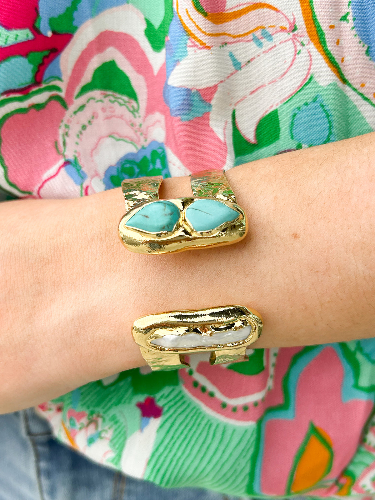 Gold double cuff bracelet featuring a mother of pearl on one end and a turquoise stone on the other—elegant, stylish, and stackable.