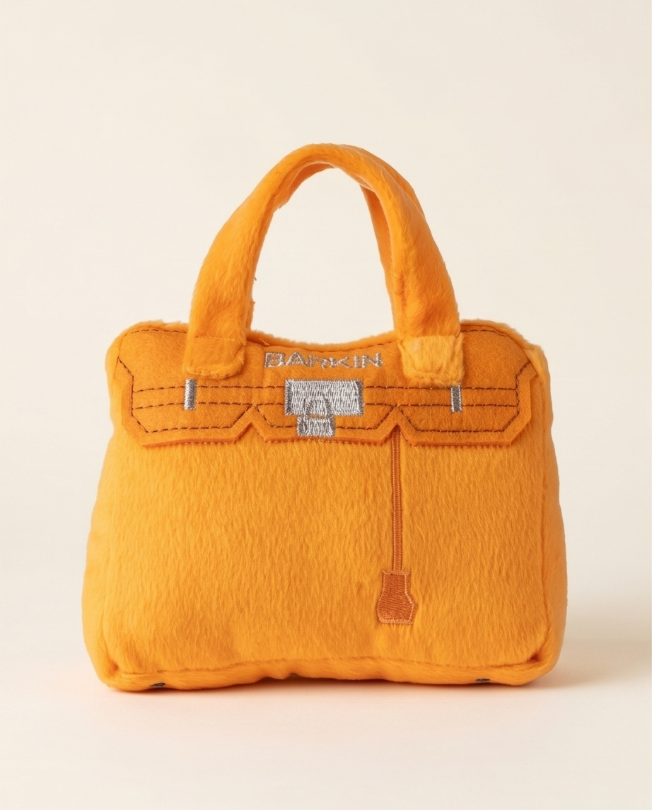 Bright orange plush handbag-shaped dog toy with a built-in squeaker.