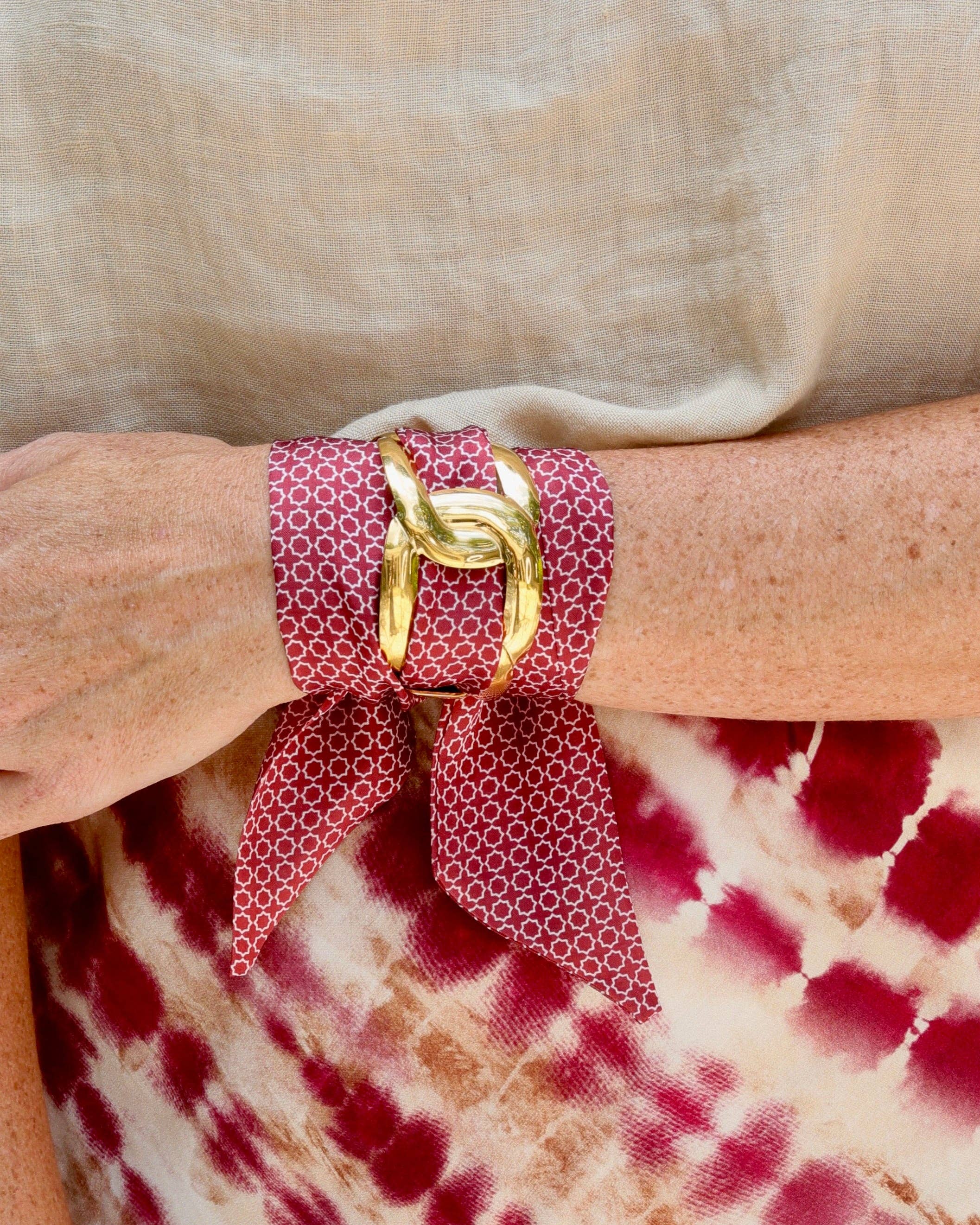 Garnet scarf bracelet with white geometric pattern threaded through adjustable stainless steel cuff