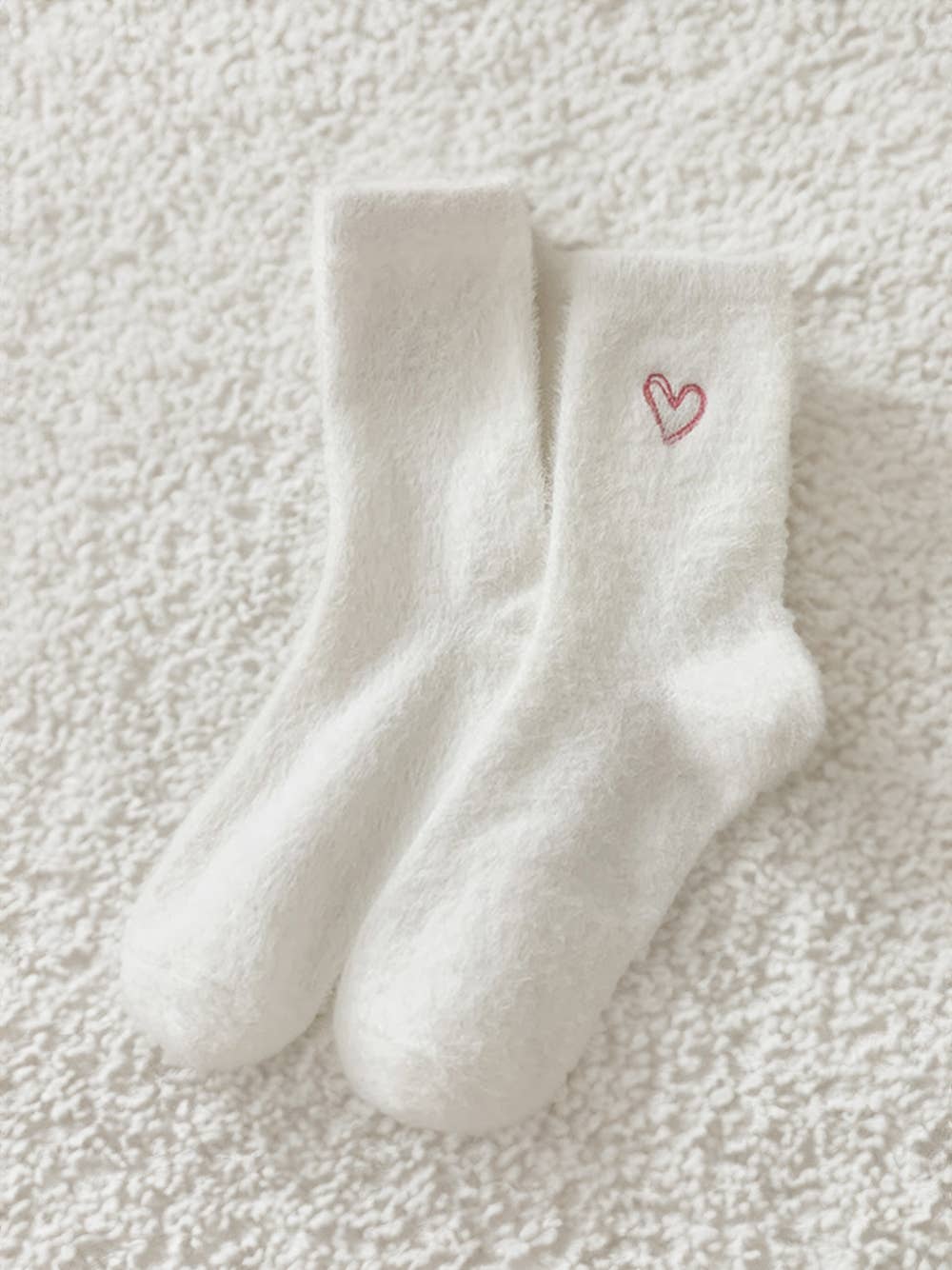 White fuzzy crew socks with a small embroidered red heart on the side.