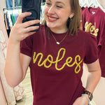 Lightweight garnet short-sleeve sweater top with gold tinsel “Noles” lettering across the chest