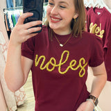 Lightweight garnet short-sleeve sweater top with gold tinsel “Noles” lettering across the chest