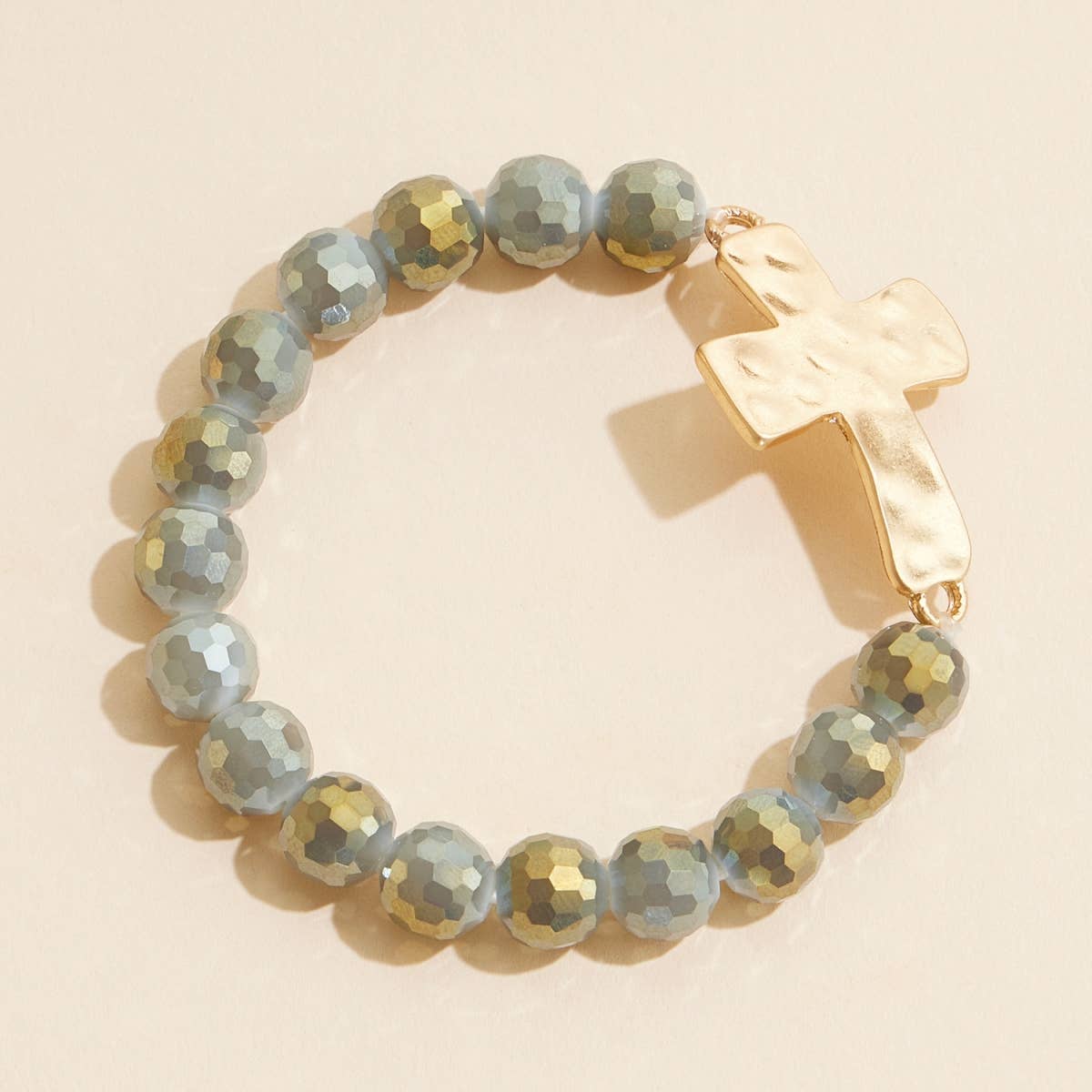 Gray glass beaded stretch bracelet with hammered metal cross charm.