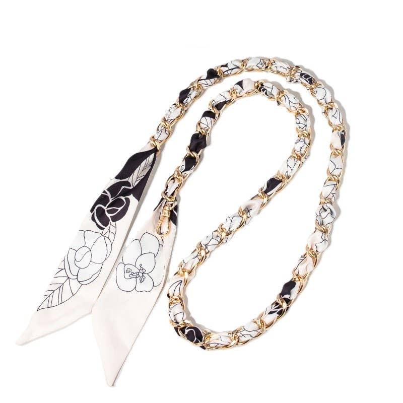 Black and cream floral scarf woven through gold chain bag strap with clasps.