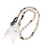 Black and cream floral scarf woven through gold chain bag strap with clasps.