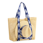 Beige woven tote bag with navy fish strap details and matching beige woven sun hat with fish wrap