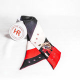 A small silk scarf featuring a University of Georgia bulldog wearing a scarf, styled with a gold-toned horseshoe charm for multiple ways to wear.