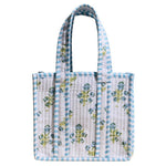 White quilted tote bag with blue and green floral pattern and matching handles