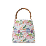 Bucket bag with colorful pagoda-inspired print featuring lanterns, bridges, palm trees, and willow trees with bamboo handle.