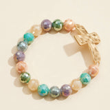 Multicolor glass beaded stretch bracelet featuring a hammered metal cross charm.