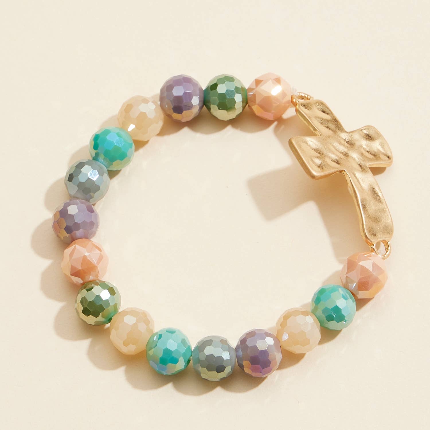 Multicolor glass beaded stretch bracelet featuring a hammered metal cross charm.