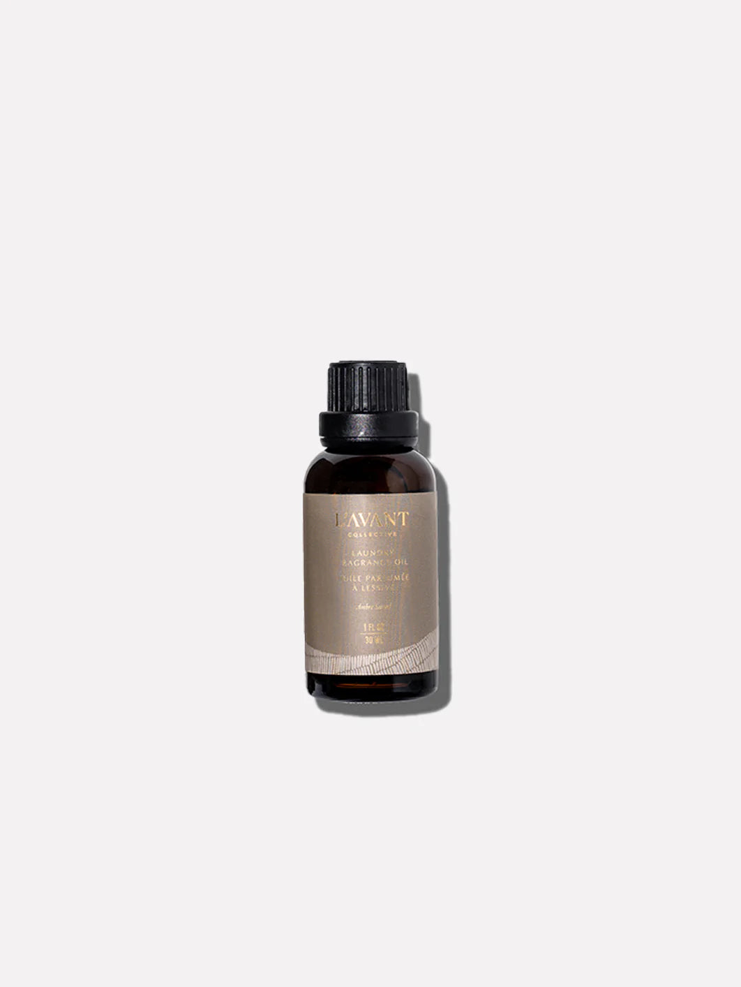 L'AVANT Ambre Santal Laundry Oil in a 1 oz bottle designed for use with wool dryer balls to fragrance laundry