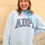Light blue oversized mock neck sweatshirt with ADPI gingham appliqué lettering across the front.