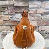 Camel faux suede slouchy shoulder bag with gold chain straps and drawstring-style closure.