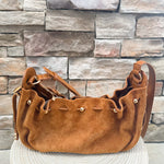 Camel faux suede slouchy shoulder bag with gold chain straps and drawstring-style closure.