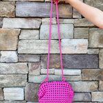 Hot pink woven handbag with a braided texture and knotted strap detail, offering a vibrant and chic everyday style.