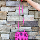 Hot pink woven handbag with a braided texture and knotted strap detail, offering a vibrant and chic everyday style.