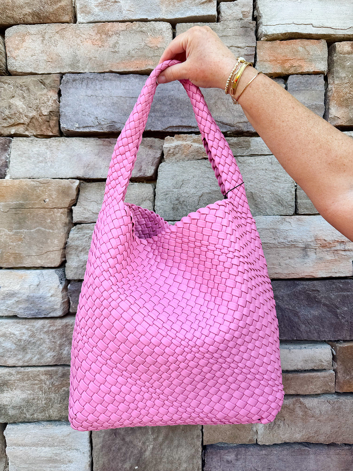 Trendy pink woven handbag with a soft, luxurious texture and modern silhouette—perfect for spring outfits.