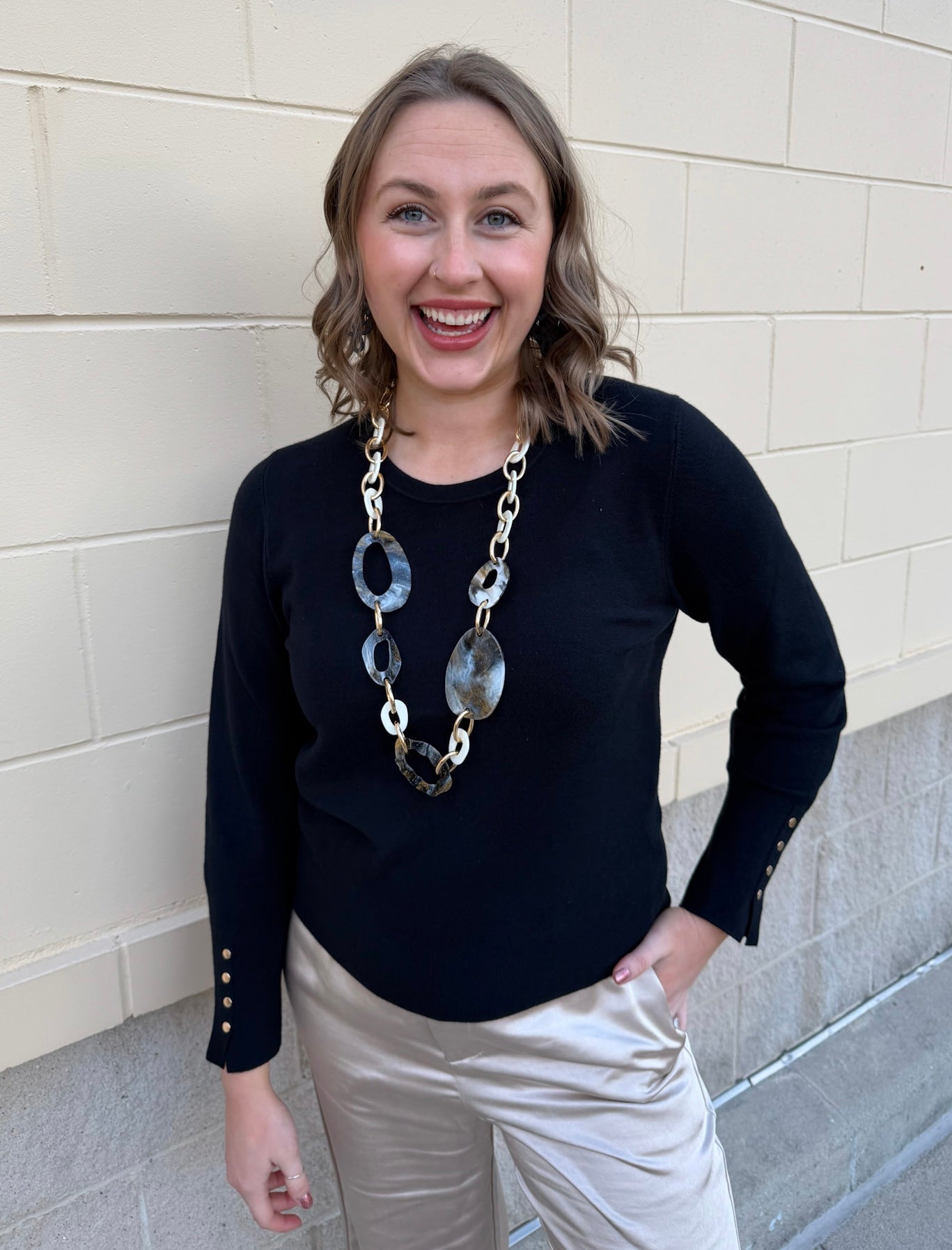 Black long sleeve knit top with button cuff details