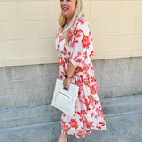 Cream midi dress with pink and orange floral print, scoop neckline, elastic waist, and flowy dolman sleeves.