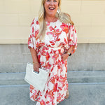 Cream midi dress with pink and orange floral print, scoop neckline, elastic waist, and flowy dolman sleeves.