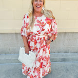 Cream midi dress with pink and orange floral print, scoop neckline, elastic waist, and flowy dolman sleeves.