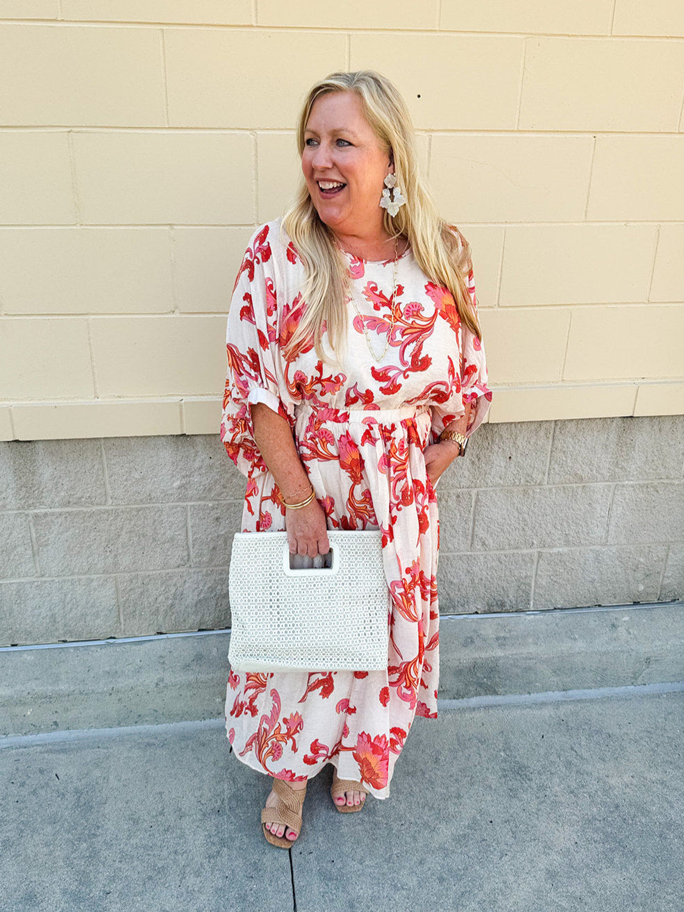 Cream midi dress with pink and orange floral print, scoop neckline, elastic waist, and flowy dolman sleeves.