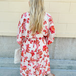 Cream midi dress with pink and orange floral print, scoop neckline, elastic waist, and flowy dolman sleeves.