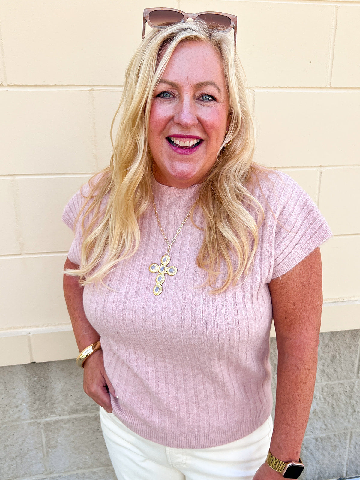 Women’s blush pink ribbed sweater top with crew neckline, short cap sleeves, and relaxed fit.