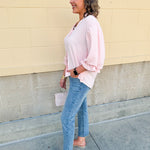 Blush blouse with V-neckline, balloon sleeves, front pleat, and ruffle-trimmed cuffs
