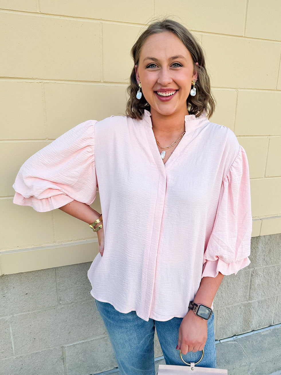 Blush blouse with V-neckline, balloon sleeves, front pleat, and ruffle-trimmed cuffs