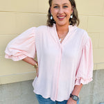 Blush blouse with V-neckline, balloon sleeves, front pleat, and ruffle-trimmed cuffs