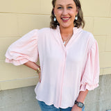 Blush blouse with V-neckline, balloon sleeves, front pleat, and ruffle-trimmed cuffs