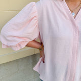 Blush blouse with V-neckline, balloon sleeves, front pleat, and ruffle-trimmed cuffs
