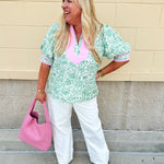 Green floral print caftan-style top with puff sleeves, split neckline, and lightweight fabric for effortless style.