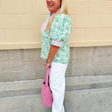 Green floral print caftan-style top with puff sleeves, split neckline, and lightweight fabric for effortless style.