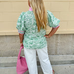 Green floral print caftan-style top with puff sleeves, split neckline, and lightweight fabric for effortless style.