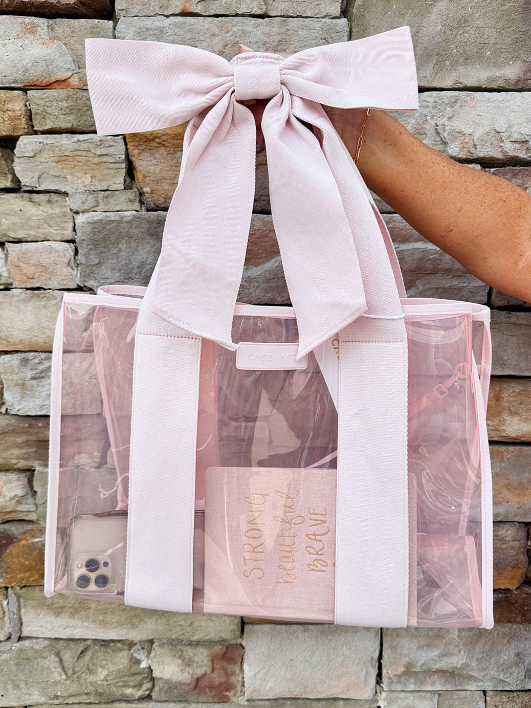 Stylish bow-accented beach tote with woven straps, water-resistant material, and matching phone pouch.