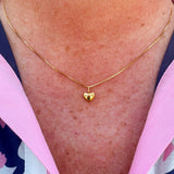 Dainty gold heart pendant necklace with a sleek box chain and toggle clasp, styled for everyday elegance.