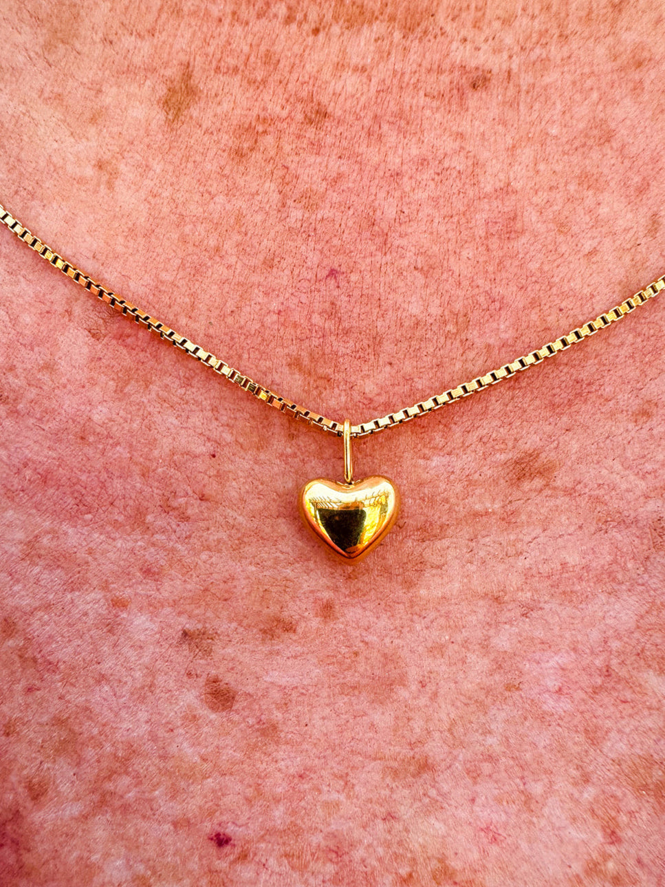 Dainty gold heart pendant necklace with a sleek box chain and toggle clasp, styled for everyday elegance.