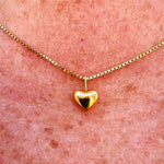 Dainty gold heart pendant necklace with a sleek box chain and toggle clasp, styled for everyday elegance.