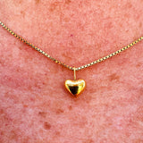 Dainty gold heart pendant necklace with a sleek box chain and toggle clasp, styled for everyday elegance.