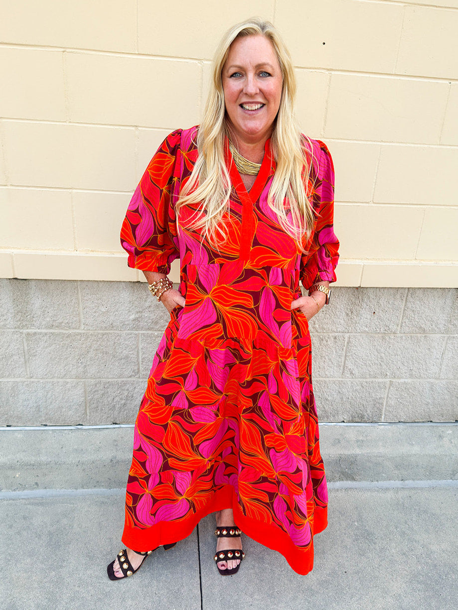 Pink, orange, and brown floral midi dress with v-neckline, tiered skirt, and ¾ puff sleeves.