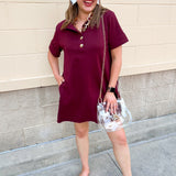 Garnet short sleeve A-line dress with collared neckline, three gold buttons, and knee-length silhouette.